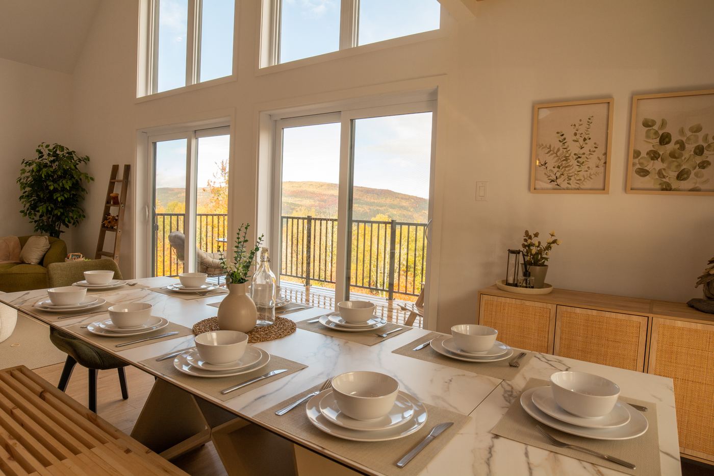 Table à manger dressée devant les grandes fenêtres et la vue sur les montagnes